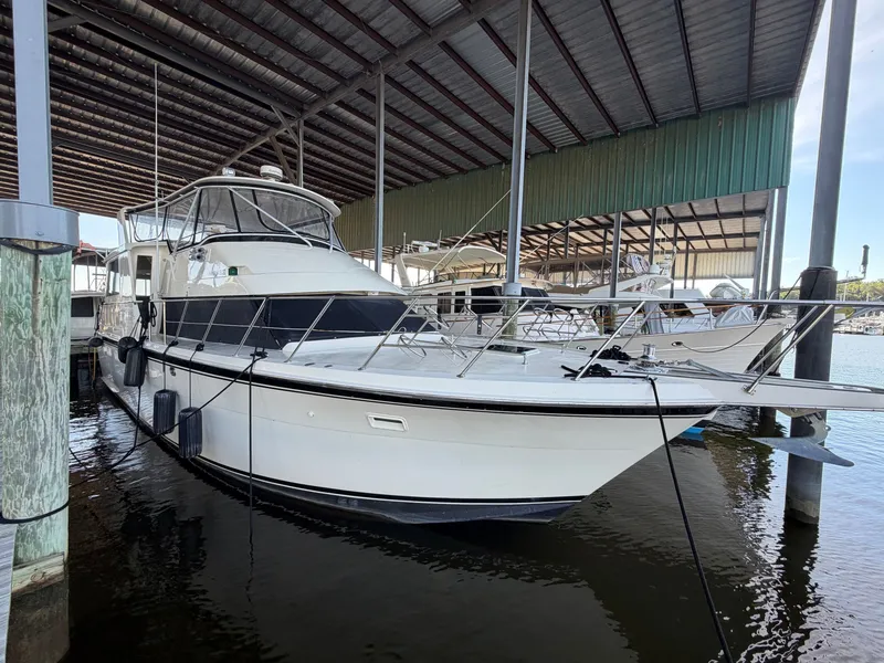 Slide: The Image of A 1991 Hatteras 52 Cockpit Motor Yacht docked in a covered marina area. - 8