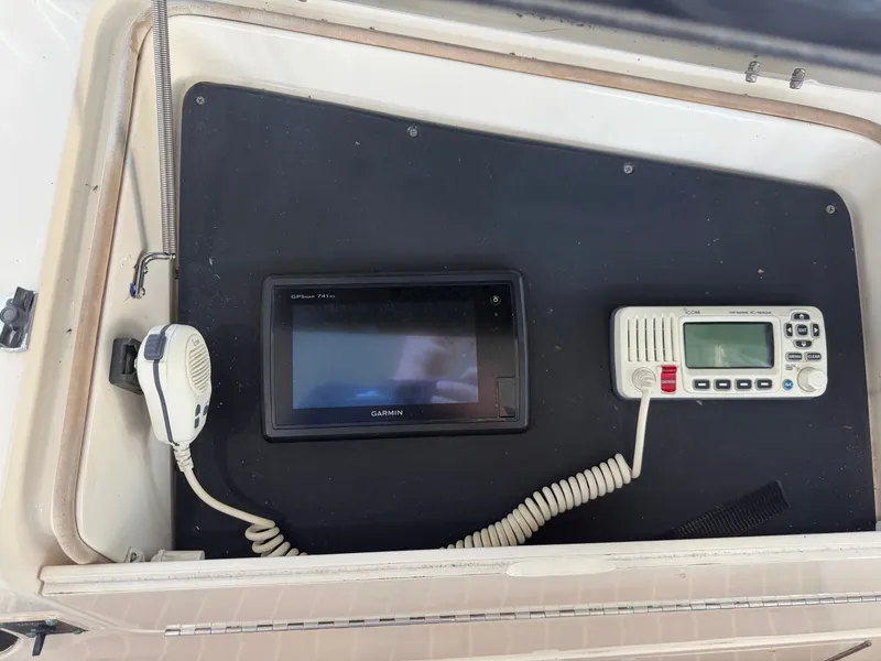 Slide: The Image of A helm station featuring a Garmin navigation device and a radio, installed in a 1991 Hatteras 52 Cockpit Motor Yacht. - 25