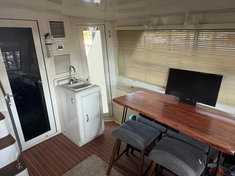 Slide: The Image of Interior of a 1991 Hatteras 52 Cockpit Motor Yacht with a sink, table, and chairs. - 15
