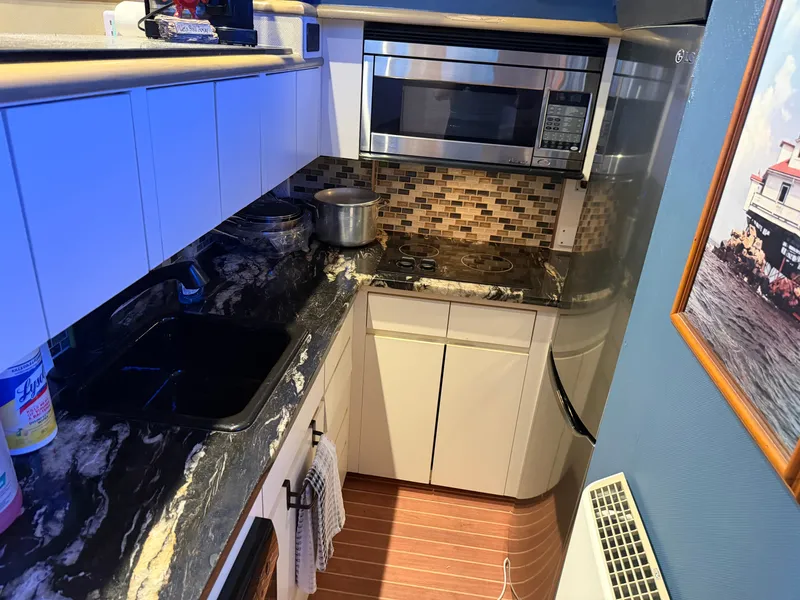 Slide: The Image of The galley of a 1991 Hatteras 52 Cockpit Motor Yacht with modern appliances and mosaic tiles. - 38