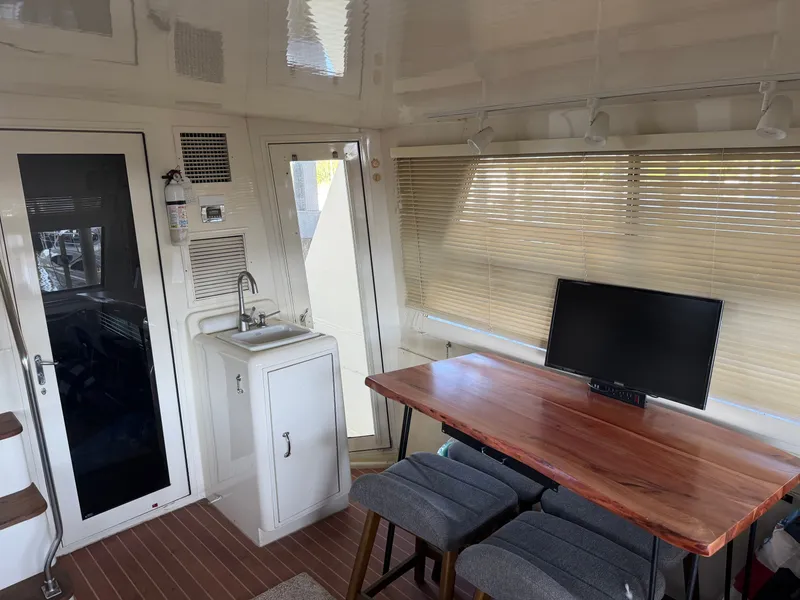 Slide: The Image of Interior of a 1991 Hatteras 52 Cockpit Motor Yacht with a table, chairs, and a sink. - 17