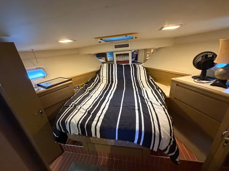 Slide: The Image of The image shows a cozy cabin with a double bed, striped bedding, and wooden furniture. - 43
