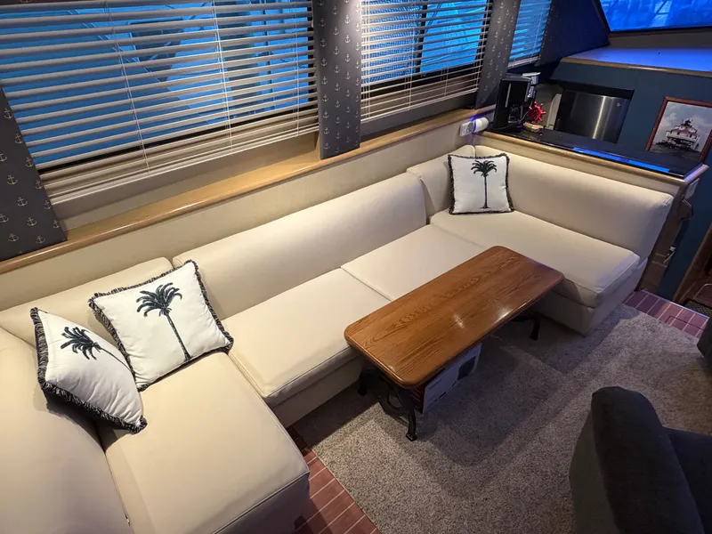 Slide: The Image of Interior of the 1991 Hatteras 52 Cockpit Motor Yacht with beige sofa and wooden table. - 30