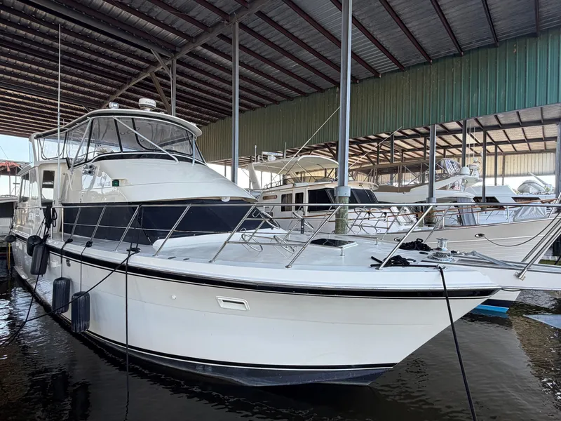 Slide: The Image of A 1991 Hatteras 52 Cockpit Motor Yacht docked in a covered marina. - 10