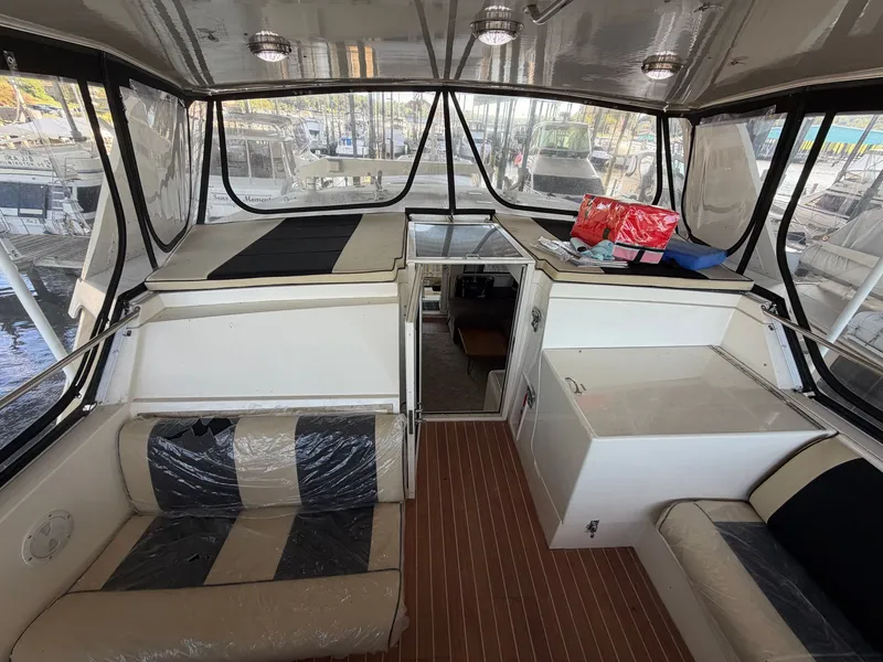 Slide: The Image of The image shows the cockpit of a 1991 Hatteras 52 Cockpit Motor Yacht with seating and storage. - 22