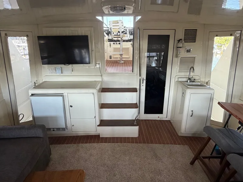 Slide: The Image of Interior of a 1991 Hatteras 52 Cockpit Motor Yacht with TV, fridge, and sink. - 12