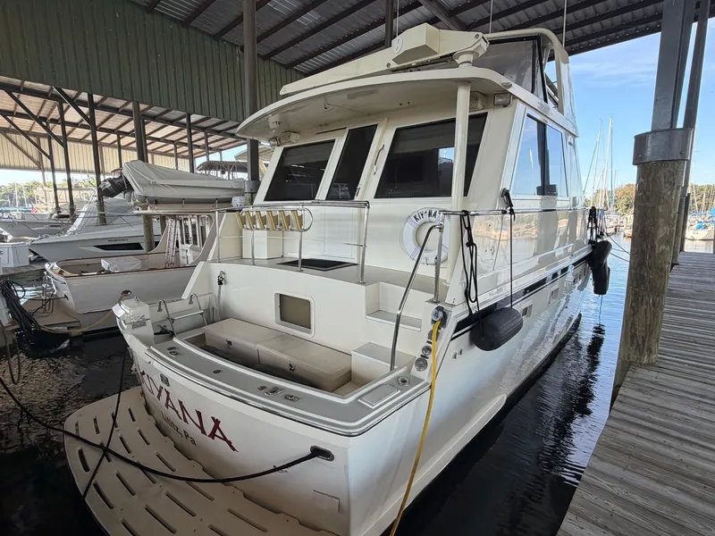 Slide: The Image of A 1991 Hatteras 52 Cockpit Motor Yacht docked in a covered marina. It features a spacious cockpit and multiple windows. - 5