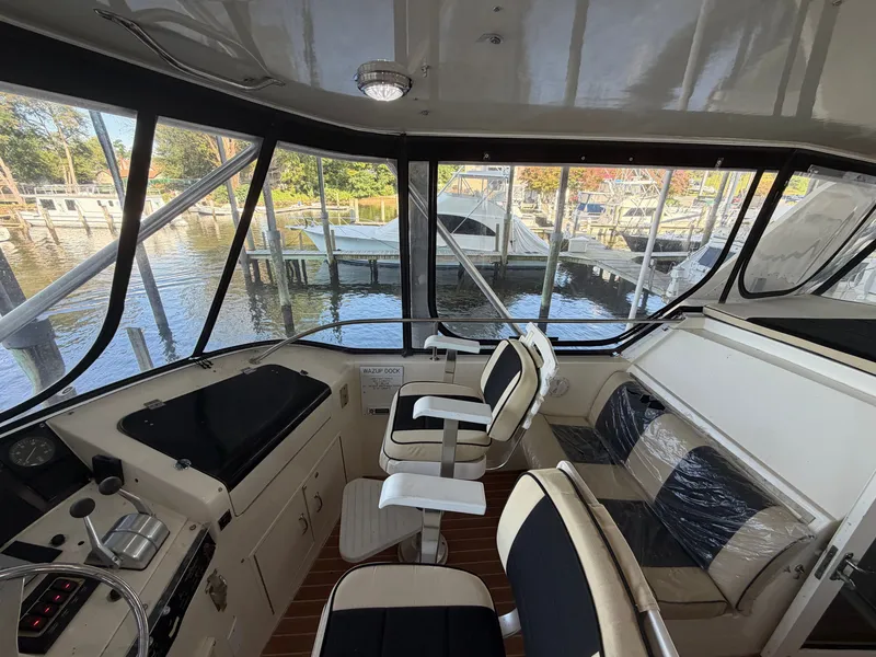 Slide: The Image of The cockpit of a 1991 Hatteras 52 Cockpit Motor Yacht with sleek seating and large windows. - 21