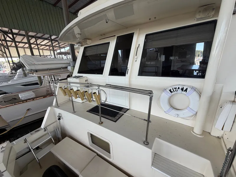 Slide: The Image of The 1991 Hatteras 52 Cockpit Motor Yacht features a spacious aft deck with seating and a lifebuoy. - 11