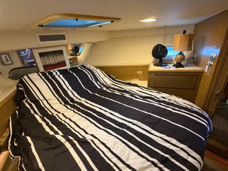 Slide: The Image of The image shows a cozy cabin with a striped bedspread, a fan, and a lamp. - 44