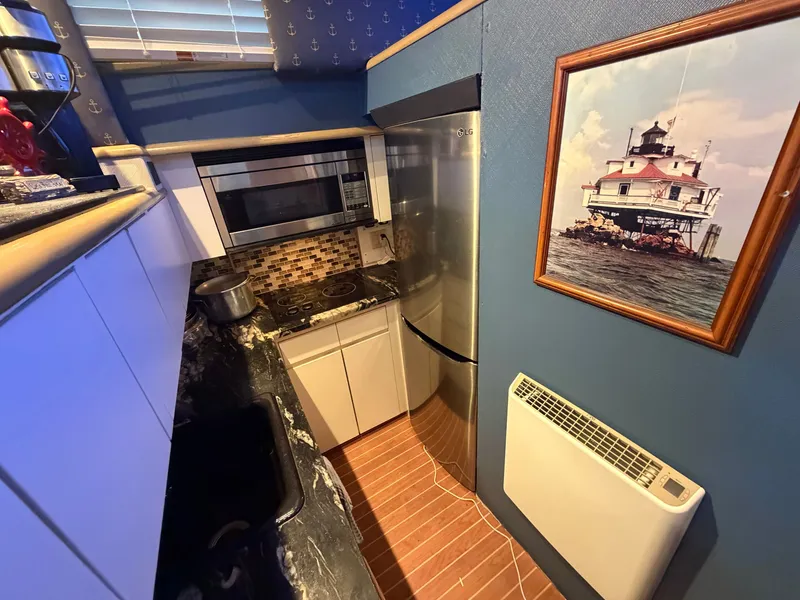 Slide: The Image of The galley of a 1991 Hatteras 52 Cockpit Motor Yacht with modern appliances and nautical decor. - 39