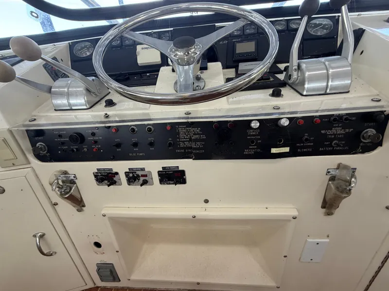 Slide: The Image of The image shows the helm of a 1991 Hatteras 52 Cockpit Motor Yacht with various instruments. - 26