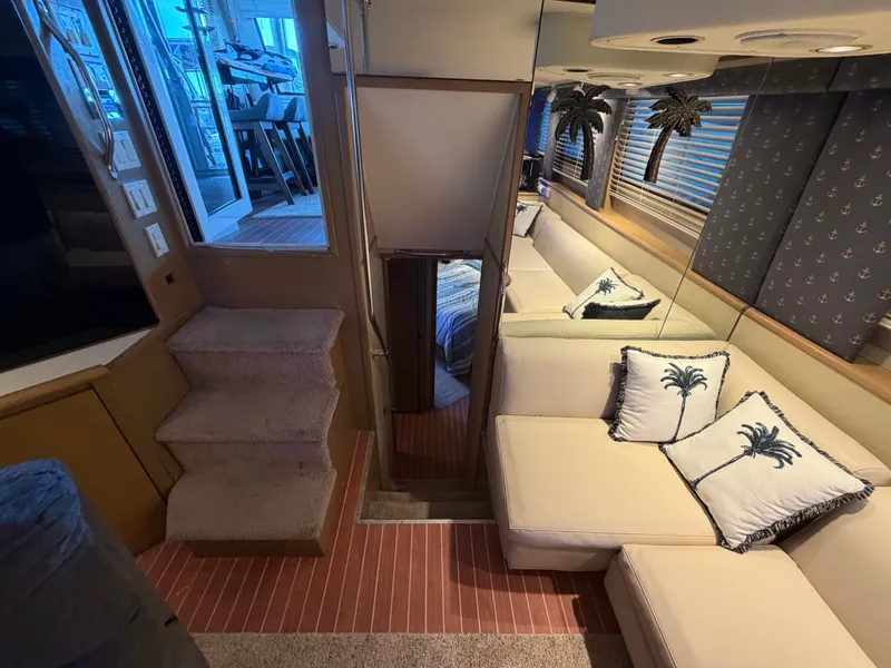 Slide: The Image of Interior of a 1991 Hatteras 52 Cockpit Motor Yacht with beige sofa and palm tree pillows. - 48