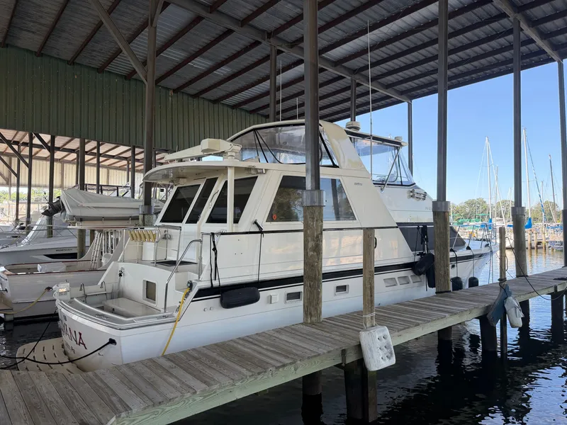 Slide: The Image of A 1991 Hatteras 52 Cockpit Motor Yacht docked in a covered marina area. - 0