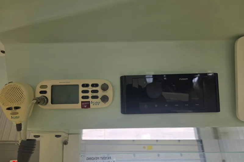 Slide: The Image of 2007 Everglades 211 Center Console boat dashboard with Cobra radio and Fusion stereo system. - 13