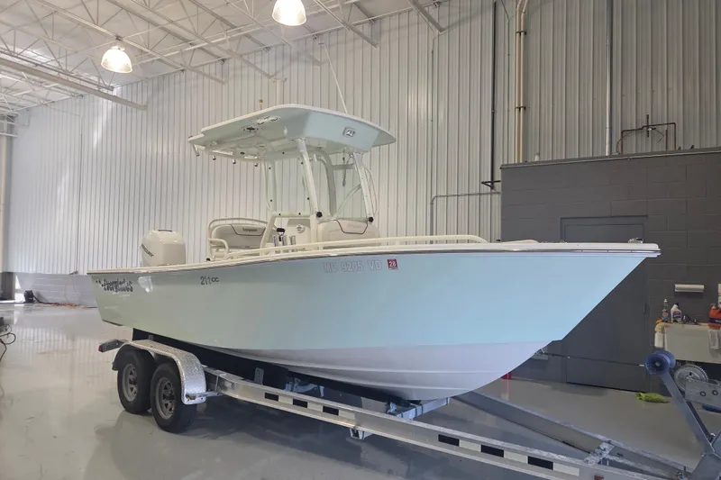 The Image of 2007 Everglades 211 Center Console boat on trailer in indoor storage. - 0
