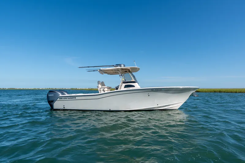 Slide: The Image of 2023 Grady-White Canyon 271 FS boat on calm water under clear blue sky. - 5