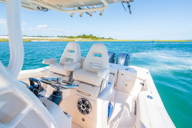 Slide: The Image of 2023 Grady-White Canyon 271 FS boat interior with dual seats on a sunny day. - 12