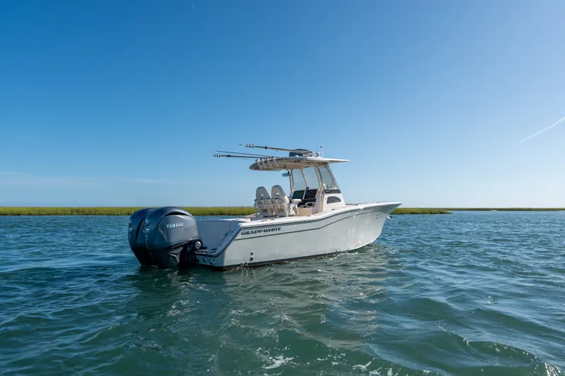 Slide: The Image of 2023 Grady-White Canyon 271 FS boat on open water under clear blue sky. - 4