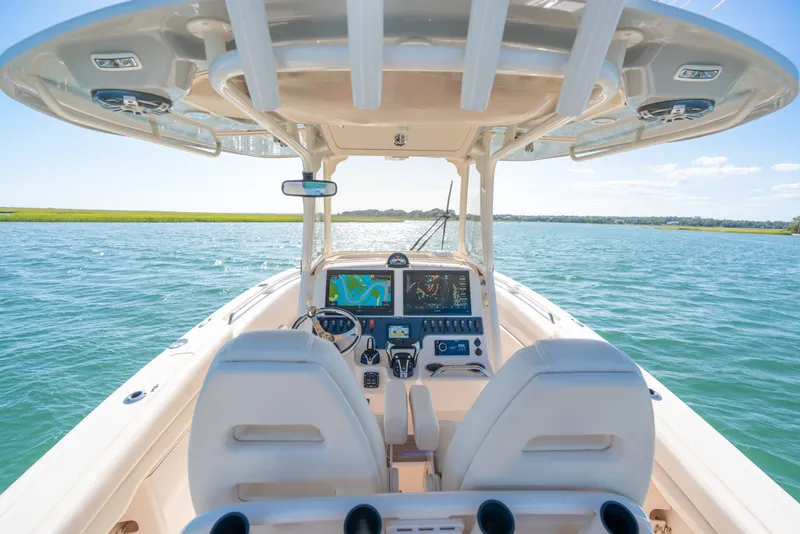 Slide: The Image of 2023 Grady-White Canyon 271 FS boat interior with advanced navigation system on open water. - 13