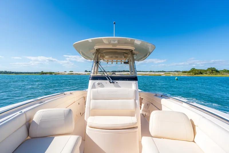 Slide: The Image of 2023 Grady-White Canyon 271 FS boat on serene blue water under clear sky. - 10