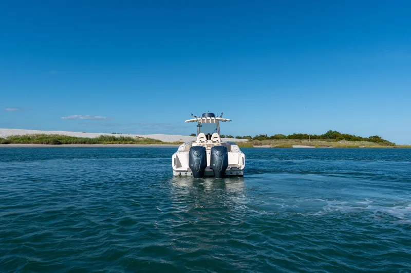 Slide: The Image of 2023 Grady-White Canyon 271 FS boat on calm water under clear blue sky. - 3
