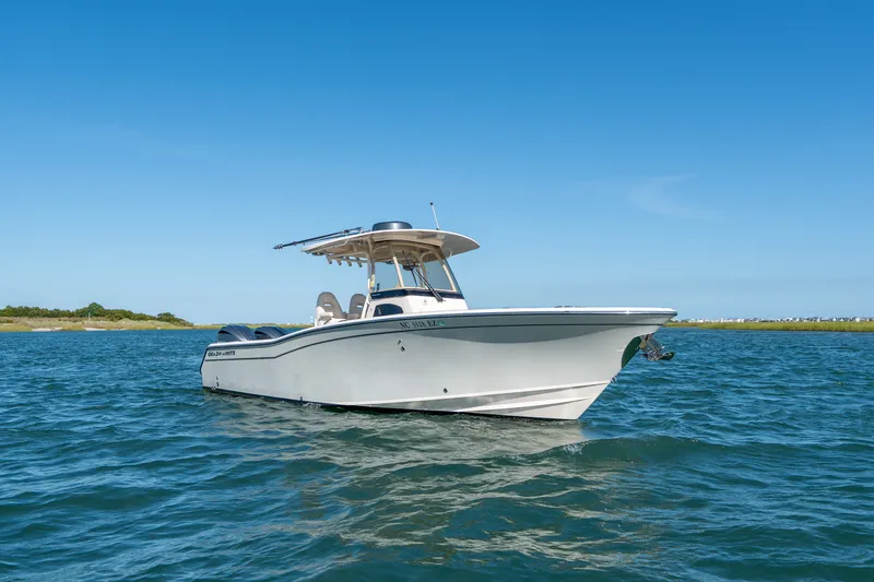Slide: The Image of 2023 Grady-White Canyon 271 FS boat on calm blue water under clear sky. - 6