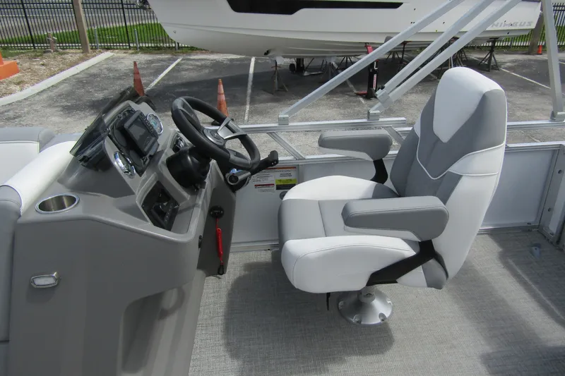 Slide: The Image of 2026 Tahoe Pontoon Sport 85 Versatile Rear Bench helm with modern steering and seating. - 16