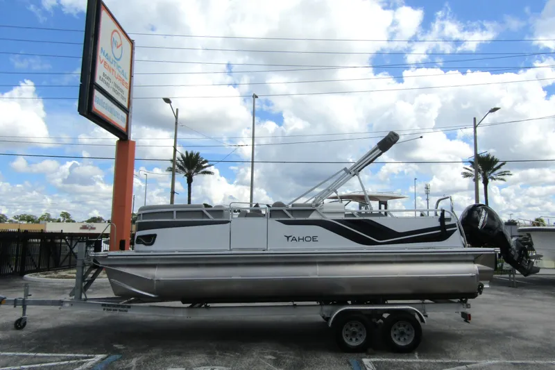 The Image of 2026 Tahoe Pontoon Sport 85 Versatile Rear Bench on trailer, parked outdoors under cloudy sky. - 0