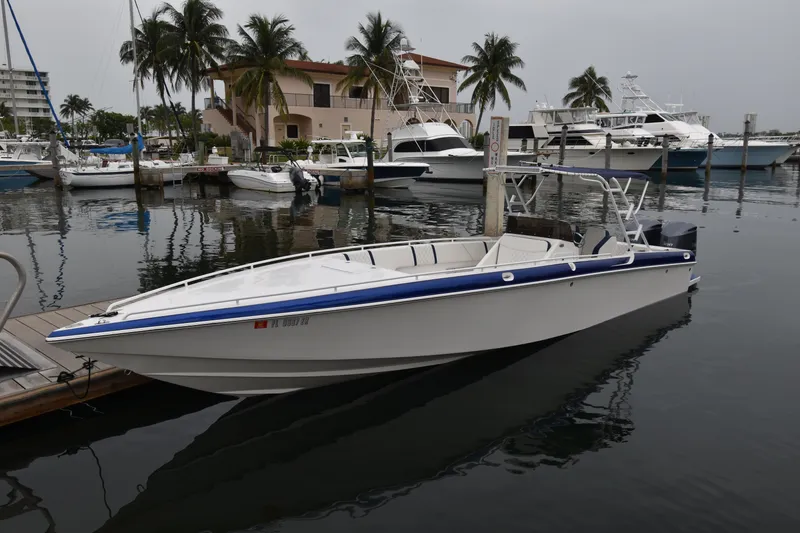 Slide: The Image of 1984 Chris-Craft Scorpion boat docked in a marina with palm trees. - 0
