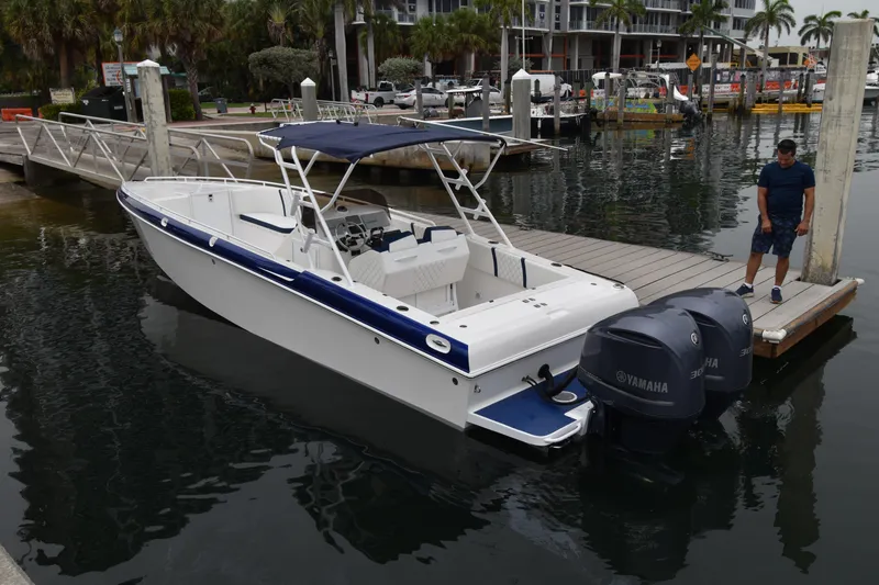 Slide: The Image of 1984 Chris-Craft Scorpion boat docked with Yamaha engines, marina background. - 1