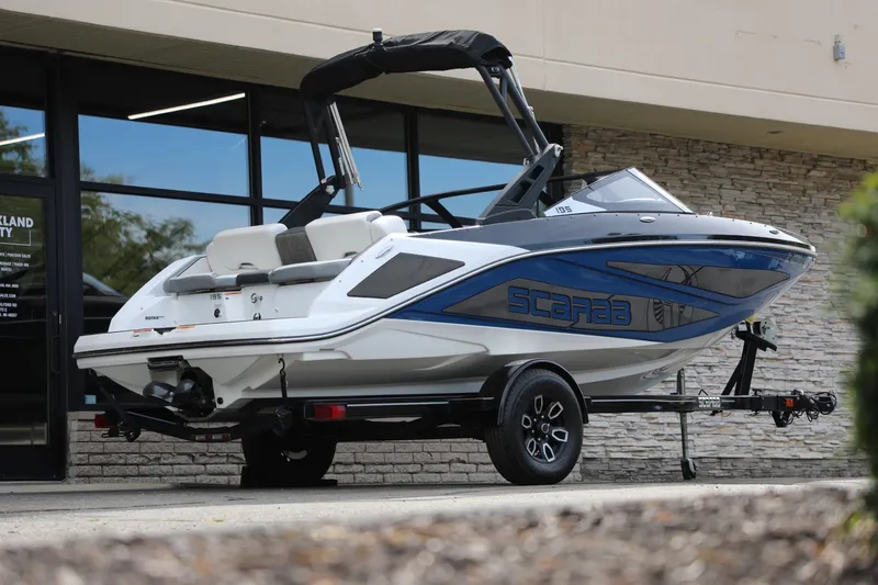Slide: The Image of 2023 Scarab 195 ID boat on trailer, parked outside a building. - 4