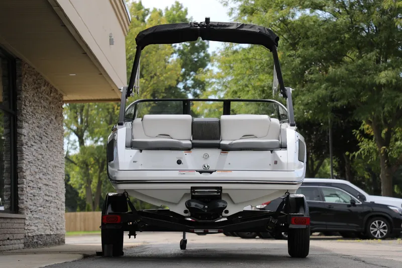 Slide: The Image of 2023 Scarab 195 ID boat on trailer, parked outdoors near building. - 3