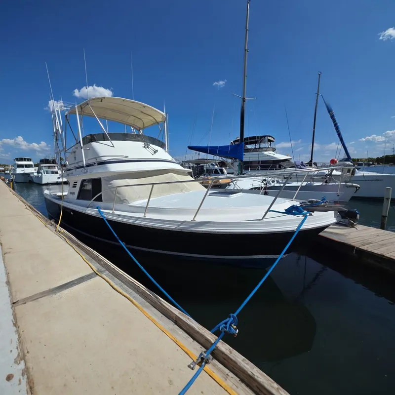 The Image of 1987 Blackfin 29 Combi boat docked at marina under clear blue sky. - 0