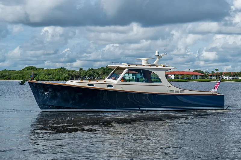 Slide: The Image of 2009 Hinckley Picnic Boat 37 MKIII cruising on calm waters under a cloudy sky. - 1