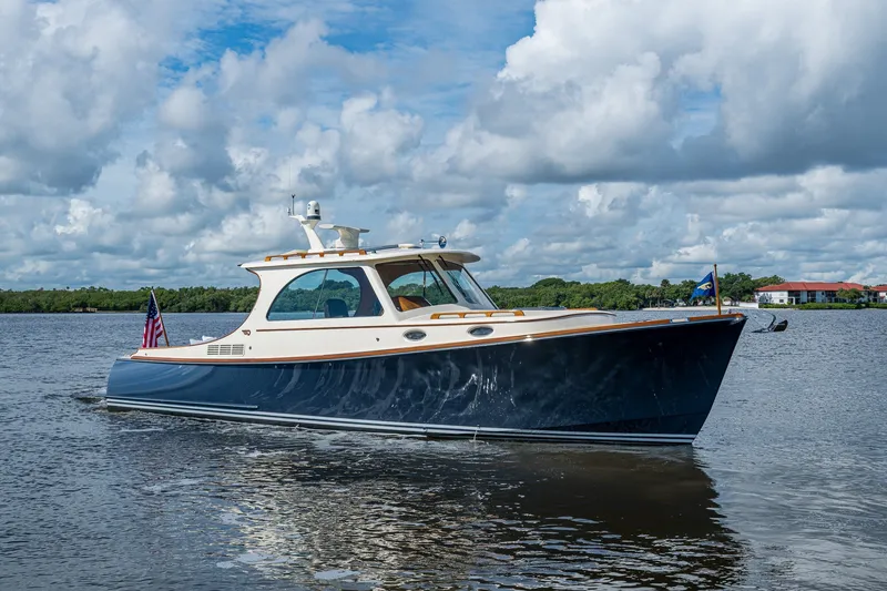 Slide: The Image of 2009 Hinckley Picnic Boat 37 MKIII cruising on a calm lake under a cloudy sky. - 4
