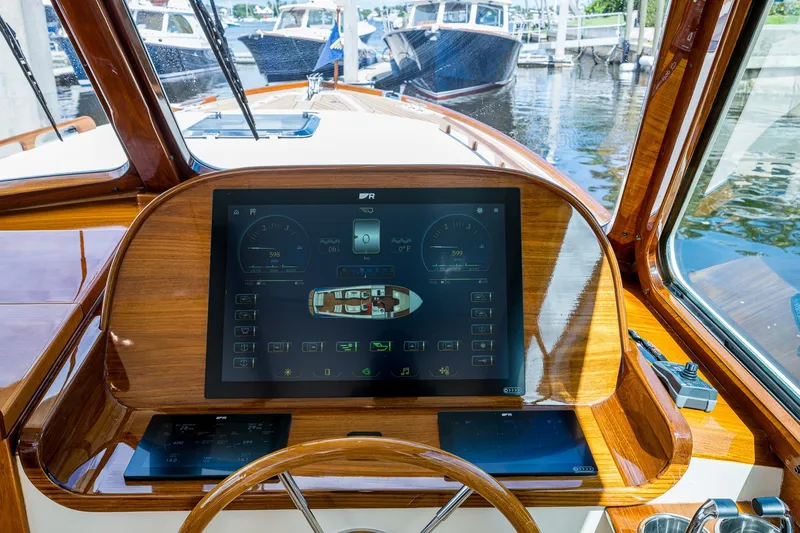 Slide: The Image of Hinckley Picnic Boat 37 MKIII 2009 dashboard with advanced navigation display in a marina setting. - 16