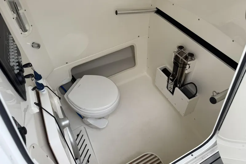 Slide: The Image of 2024 Boston Whaler 280 Outrage interior cabin with toilet and storage features. - 20