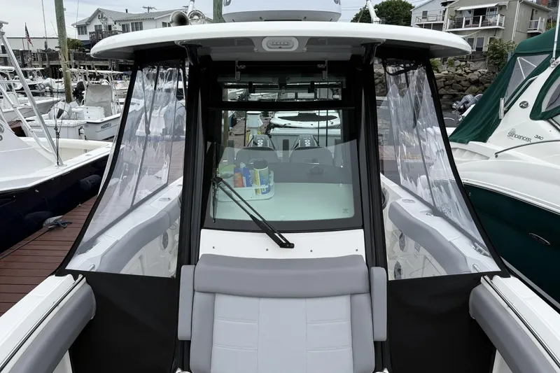 Slide: The Image of 2024 Boston Whaler 280 Outrage boat docked, showcasing cockpit and seating area. - 18