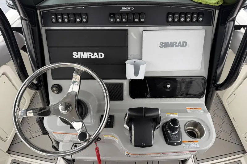 Slide: The Image of 2024 Boston Whaler 280 Outrage helm with Simrad electronics and steering wheel. - 13