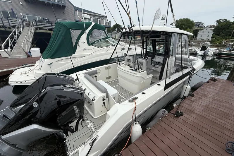 Slide: The Image of 2024 Boston Whaler 280 Outrage docked, featuring dual Mercury engines and spacious cockpit. - 2