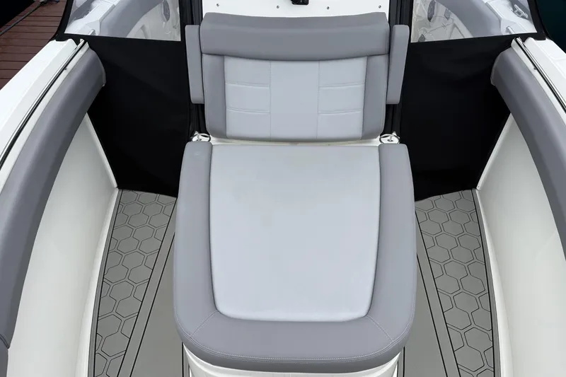 Slide: The Image of 2024 Boston Whaler 280 Outrage boat seat with gray upholstery and hexagonal floor pattern. - 16