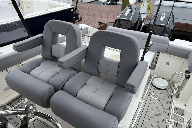 Slide: The Image of 2024 Boston Whaler 280 Outrage boat interior with dual gray captain's chairs and modern design. - 15