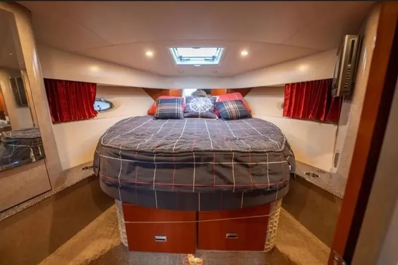 Slide: The Image of Interior cabin of a 2008 Formula 40 Performance Cruiser with cozy bedding and red curtains. - 24