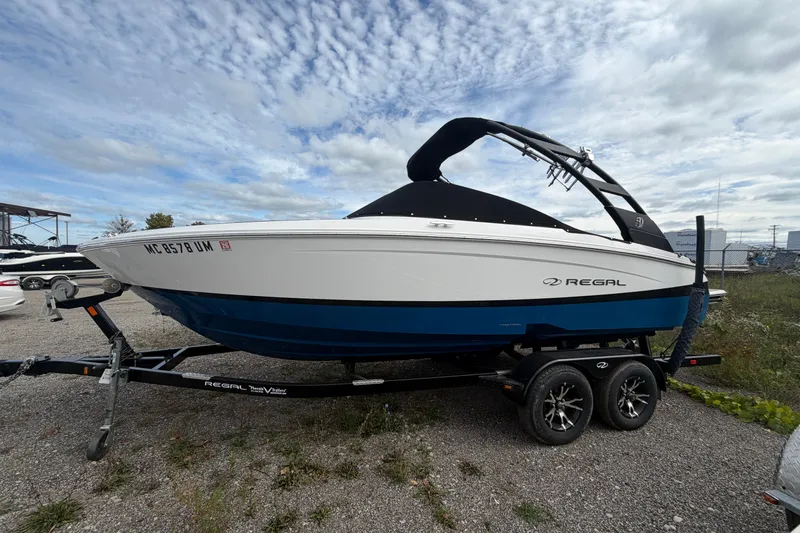 The Image of 2021 Regal LS2 Surf boat on trailer under cloudy sky. - 0