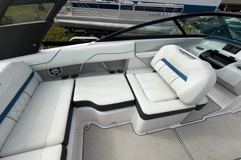 Slide: The Image of Luxurious interior of 2021 Regal LS2 Surf boat with white seating and blue accents. - 7