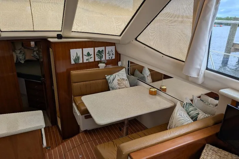 Slide: The Image of Interior of 2003 Carver 356 Motor Yacht with dining area and decorative pillows. - 23