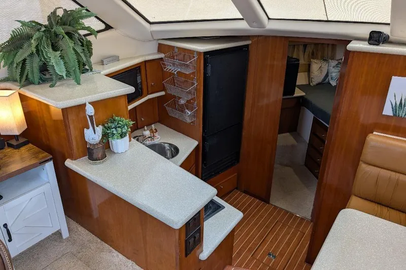 Slide: The Image of Interior of 2003 Carver 356 Motor Yacht with kitchenette and cozy seating area. - 21