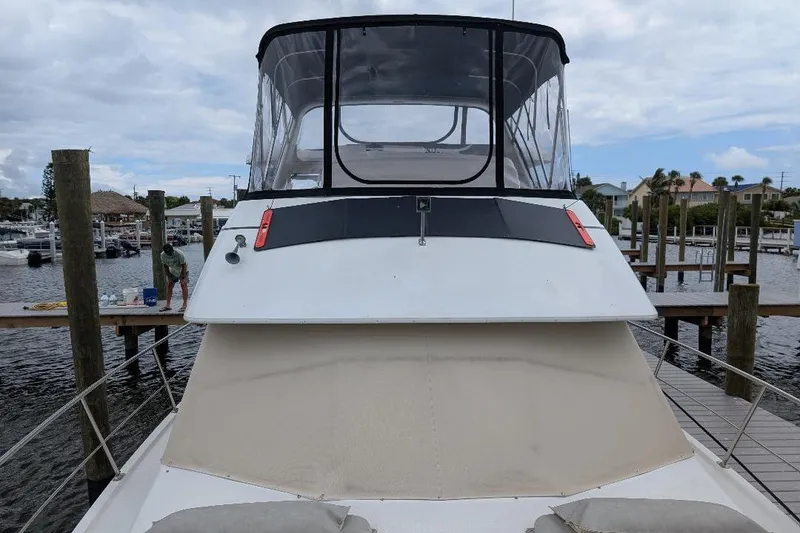 Slide: The Image of 2003 Carver 356 Motor Yacht docked at marina, featuring spacious upper deck and sleek design. - 8