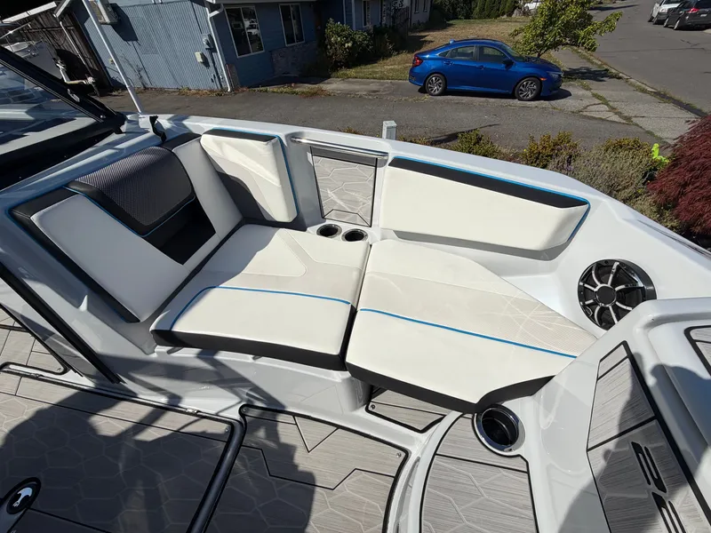 Slide: The Image of The 2023 Yamaha 222XE features a stylish cushioned seating area with blue accents and cup holders. - 24